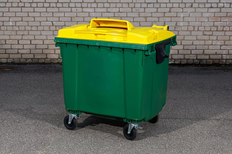 A large green recycling bin with a bright yellow lid and sturdy wheels, designed for outdoor waste collection, recycling, and eco-friendly waste management